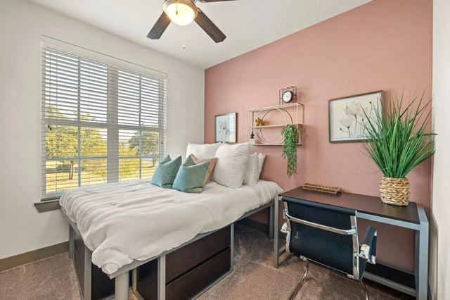 Bed desk shelf and plant bedroom at Holleman Crossing in College Station Student Accommodation