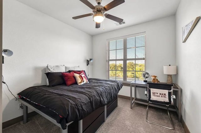 Bed desk lamp fan and pillows bedroom at Holleman Crossing in College Station Student Accommodation