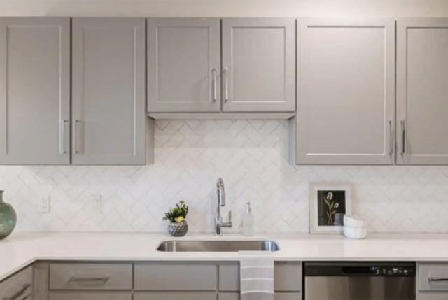 Gray cabinets sink faucet herringbone tile kitchen at The Carlton House in Lubbock Student Accommodation