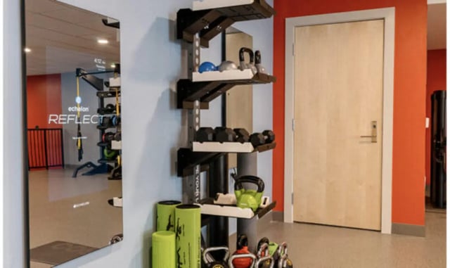 Dumbbells kettlebells mirror and door gym area at The Carlton House in Lubbock Student Accommodation