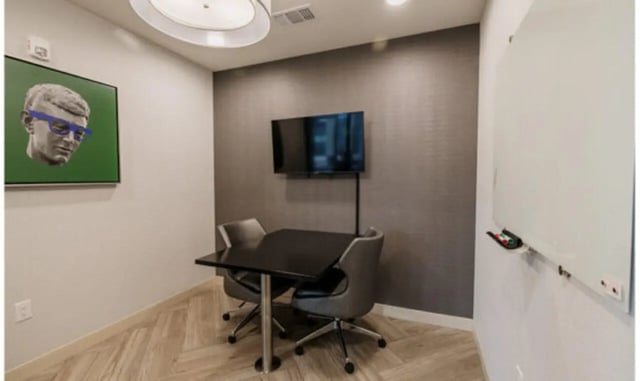 Table chairs TV framed art whiteboard meeting room at The Carlton House in Lubbock Student Accommodation