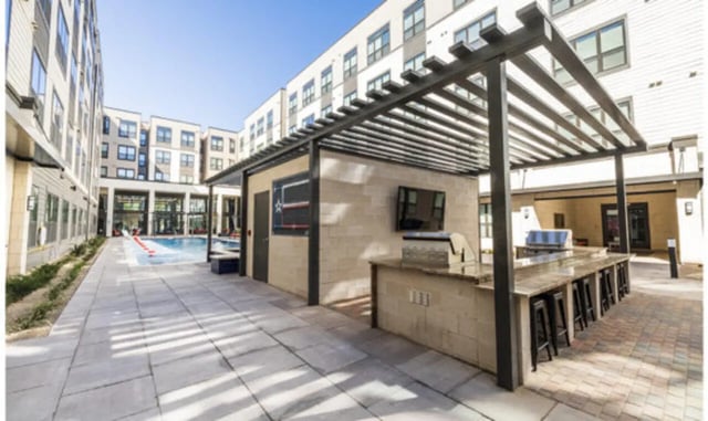 Outdoor kitchen bar with grill and seating exterior at The Carlton House in Lubbock Student Accommodation