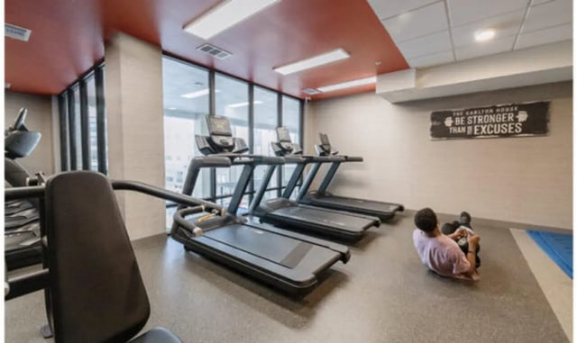 Treadmills and person exercising gym area at The Carlton House in Lubbock Student Accommodation