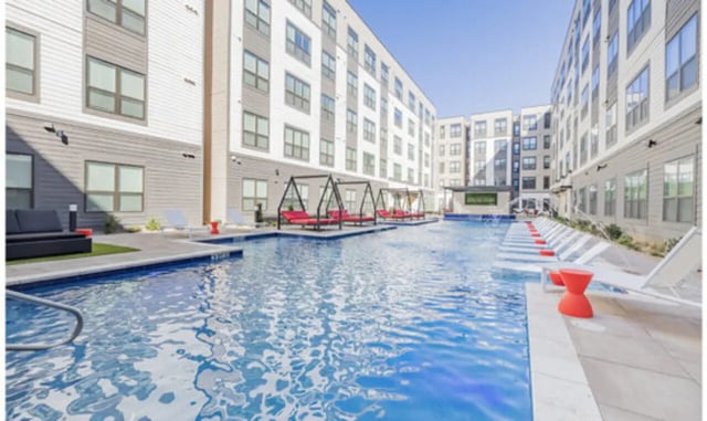 Pool with lounge chairs and cabanas exterior at The Carlton House in Lubbock Student Accommodation