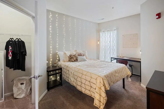 Bed with fairy lights desk closet laundry basket bedroom at University Edge Youngstown in Youngstown Student Accommodation