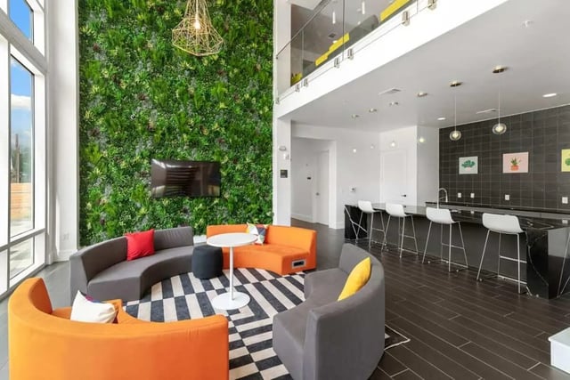 Modern seating area with green wall and kitchen living room at The View on the Square in San Marcos Student Accommodation