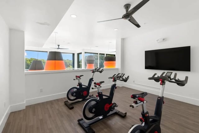 Spinning bikes near large windows and TV Fitness Area at The View on the Square in San Marcos Student Accommodation