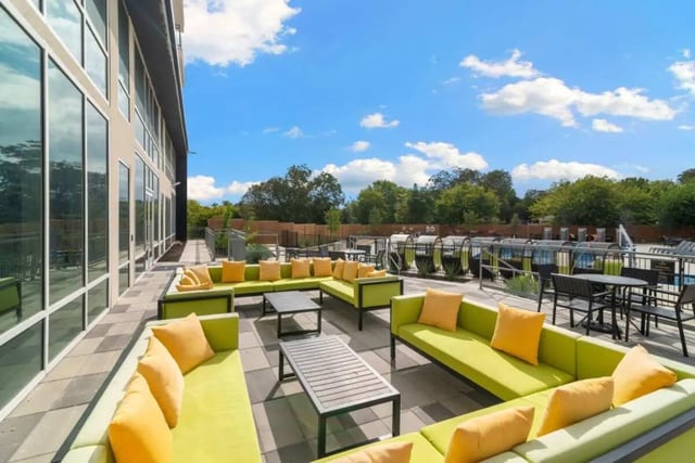 Green couches yellow pillows outdoor lounge area at The View on the Square in San Marcos Student Accommodation