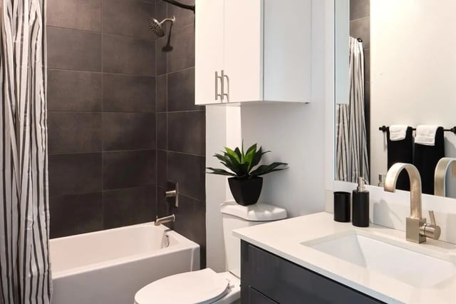Tub shower toilet sink with plant bathroom at The View on the Square in San Marcos Student Accommodation