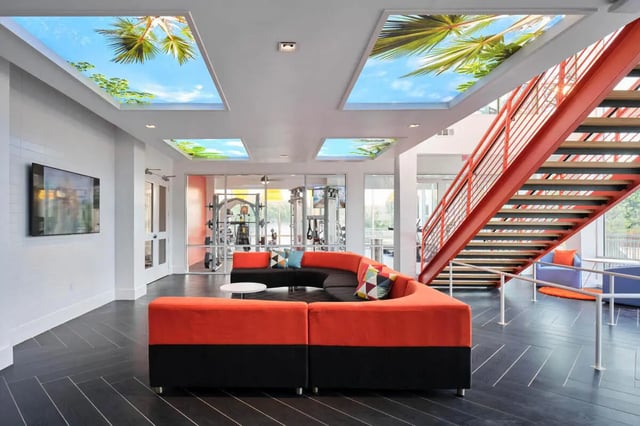 Orange sectional sofa gym stairs living area at The View on the Square in San Marcos Student Accommodation