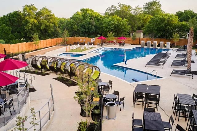 Pool with tube slide lounge chairs and tables exterior at The View on the Square in San Marcos Student Accommodation
