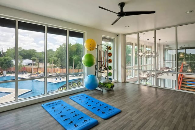 Gym with exercise balls yoga mats and pool view Gym at The View on the Square in San Marcos Student Accommodation