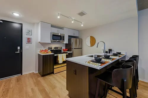 Modern kitchen island with bar stools and appliances kitchen at HERE Seattle in Seattle Student Accommodation