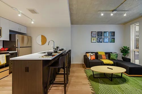 Kitchen island with stools and living room couch living room at HERE Seattle in Seattle Student Accommodation
