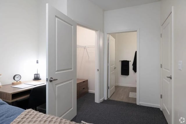 Desk lamp clock open closet and bathroom area bedroom at Paloma Kent in Kent Student Accommodation
