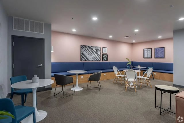 Blue sectional seating white tables chairs wall art communal area at Paloma Kent in Kent Student Accommodation