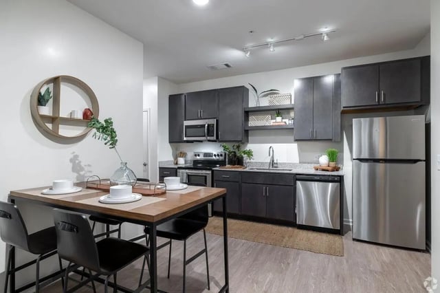 Dining table and chairs with modern kitchen at Paloma Kent in Kent Student Accommodation