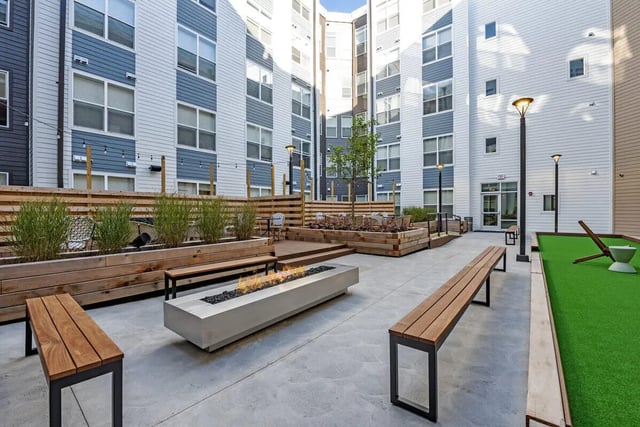 Courtyard with fire pit benches and Astroturf playing area at Paloma Kent in Kent Student Accommodation