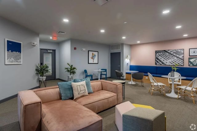 Pink sectional sofa with blue cushions and art living room at Paloma Kent in Kent Student Accommodation