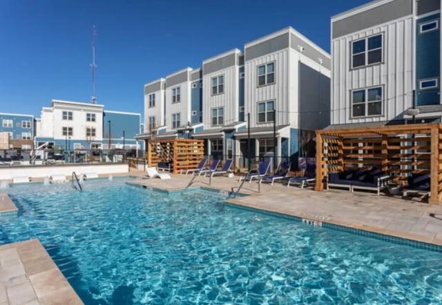 Pool lounge chairs buildings and pool exterior at Paloma Raleigh in Raleigh Student Accommodation