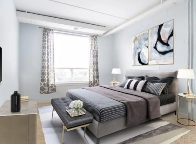 Bed with grey duvet dark bench and artwork bedroom at HH Cresmont Apartments in Baltimore Student Accommodation
