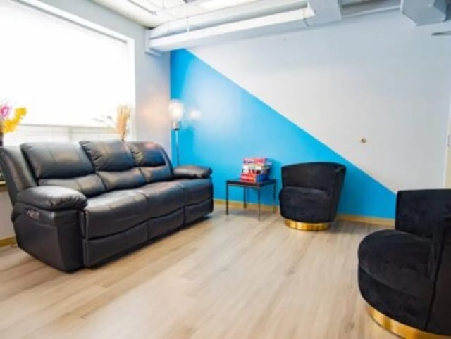 Black sofa stack of books velvet chairs living room at HH Cresmont Apartments in Baltimore Student Accommodation