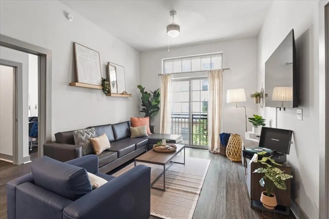 Modern living room with sectional sofa and TV Living room at Paloma West Midtown in Atlanta Student Accommodation