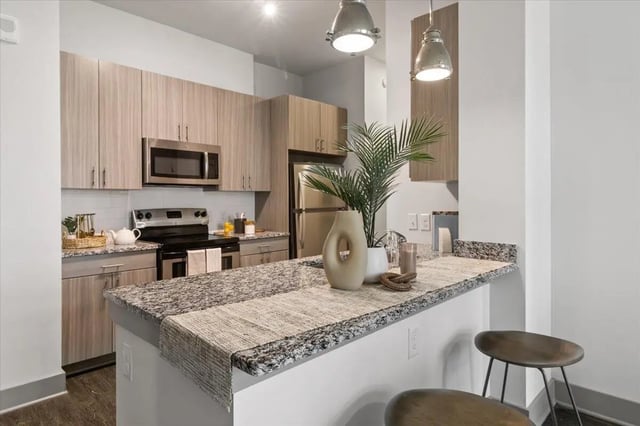 Modern kitchen with granite island and pendant lights kitchen at Paloma West Midtown in Atlanta Student Accommodation
