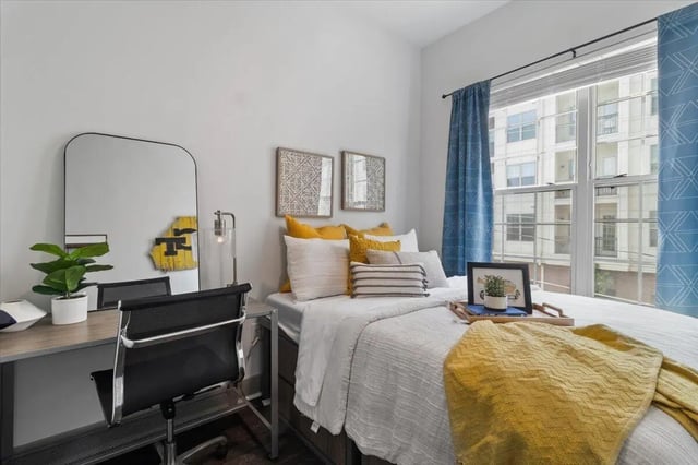 Desk mirror plant bed pillows artwork bedroom at Paloma West Midtown in Atlanta Student Accommodation
