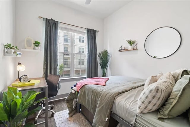 Bed desk chair shelves plants mirror bedroom at Paloma West Midtown in Atlanta Student Accommodation