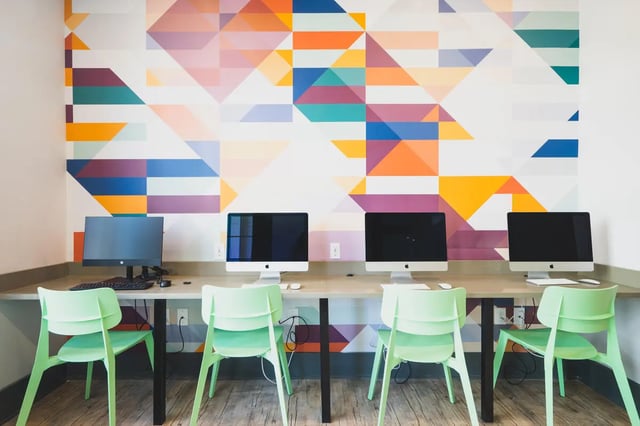 Four computers and green chairs study area at Paloma West Midtown in Atlanta Student Accommodation