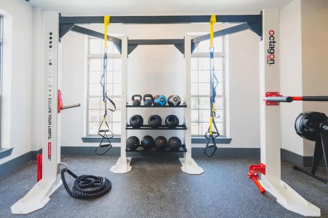 Gym equipment with weights and suspension trainers fitness room at Paloma West Midtown in Atlanta Student Accommodation