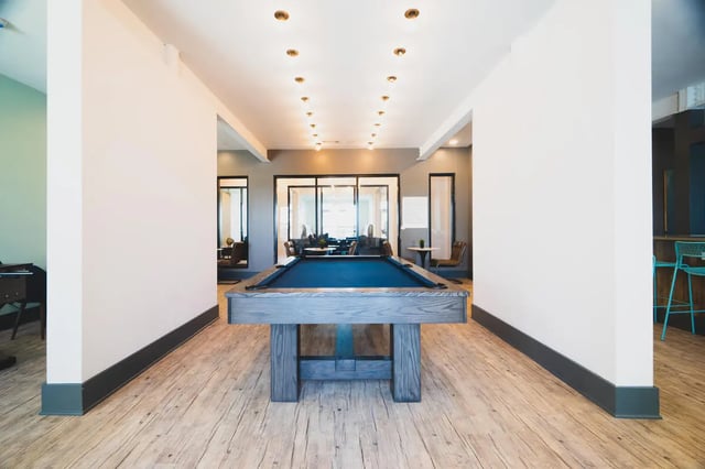 Pool table with blue felt and wooden legs playing area at Paloma West Midtown in Atlanta Student Accommodation