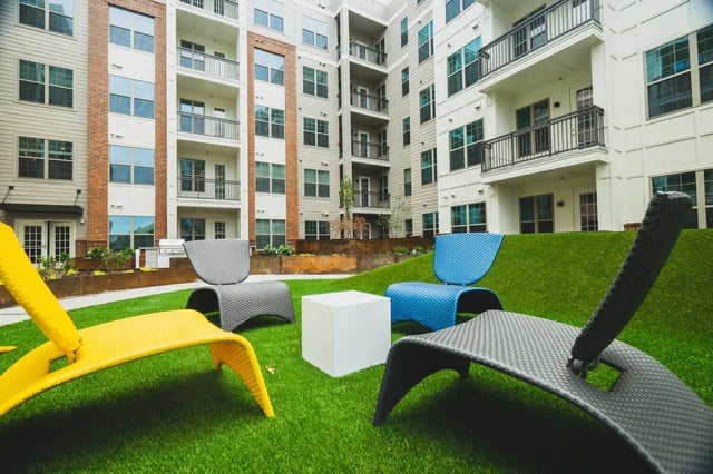 Colorful chairs on astroturf courtyard exterior at Paloma West Midtown in Atlanta Student Accommodation
