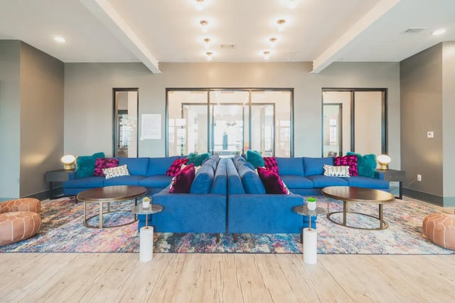 Blue couches with colorful pillows coffee tables living room at Paloma West Midtown in Atlanta Student Accommodation