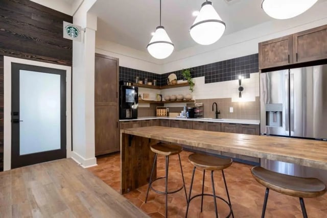 Kitchen with coffee maker refrigerator and island kitchen at University Trails College Station in College Station Student Accommodation