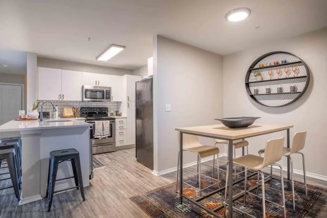 Kitchen island with stools and dining table kitchen at University Trails College Station in College Station Student Accommodation