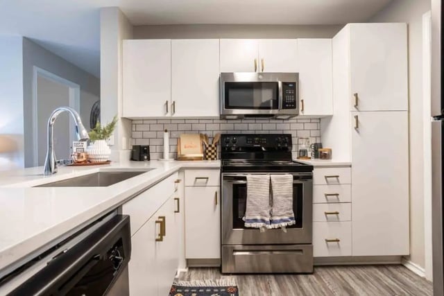 White cabinets stainless steel appliances sink kitchen at University Trails College Station in College Station Student Accommodation