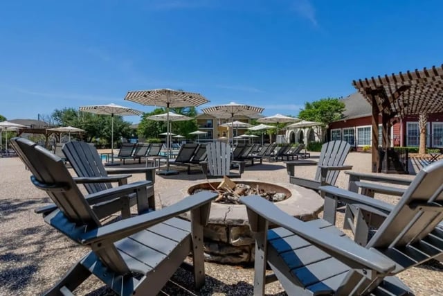 Adirondack chairs around fire pit outdoor living area at University Trails College Station in College Station Student Accommodation