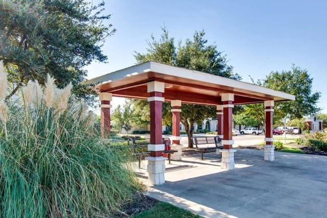 Covered outdoor seating area with benches exterior at University Trails College Station in College Station Student Accommodation