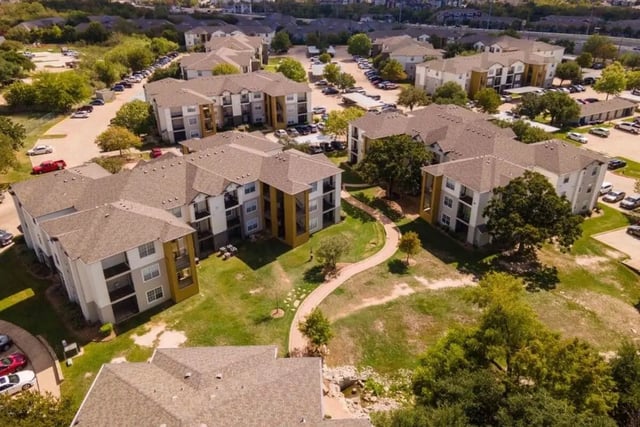 Apartment buildings with balconies and parking lots exterior at University Trails College Station in College Station Student Accommodation