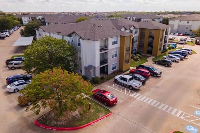 Apartment building parking lot with cars exterior at University Trails College Station in College Station Student Accommodation