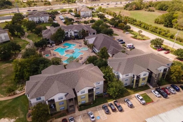Apartment buildings with pool and parking lot Exterior at University Trails College Station in College Station Student Accommodation