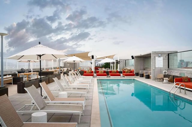 Pool lounge chairs umbrellas and seating area exterior at The Carmin in Tempe Student Accommodation