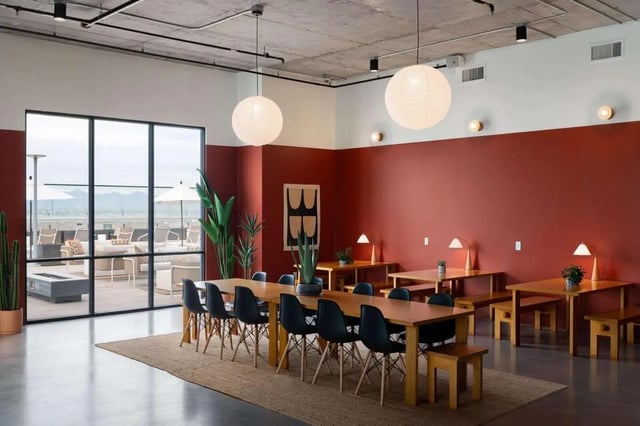 Long dining table with chairs and study tables communal area at The Carmin in Tempe Student Accommodation
