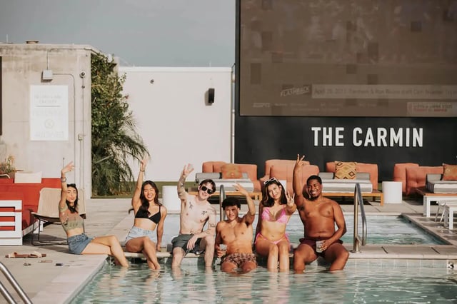 Six friends posing by swimming pool exterior at The Carmin in Tempe Student Accommodation