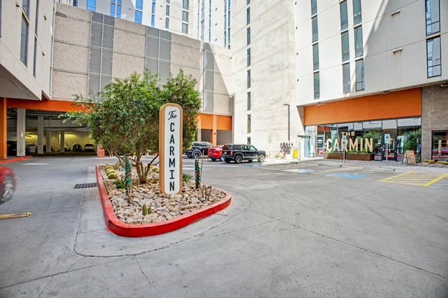 The Carmin sign and cars in parking lot Exterior at The Carmin in Tempe Student Accommodation