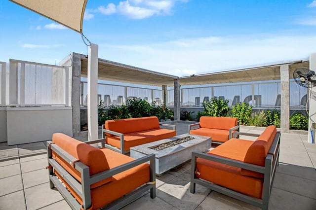 Orange sofas surrounding fire pit patio area at The Carmin in Tempe Student Accommodation