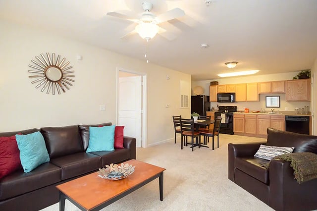 Brown couches dining table kitchen area living room at Mountain Valley Apartments in Morgantown Student Accommodation