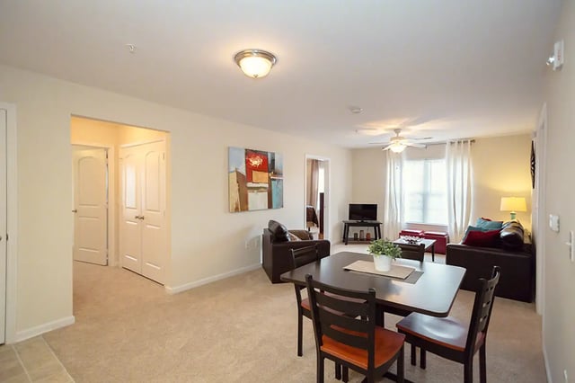 Dining table chairs sofas artwork living room at Mountain Valley Apartments in Morgantown Student Accommodation